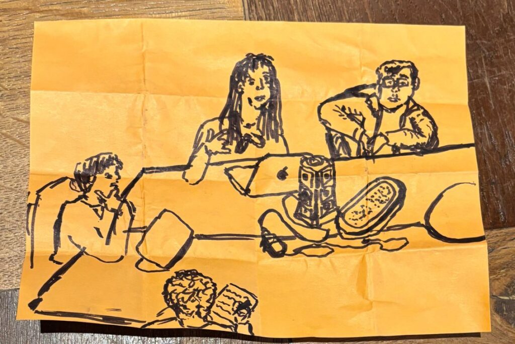 Zeichnung der Workshopteilnehmer auf einem orangefarbenen zerknitterten Blatt