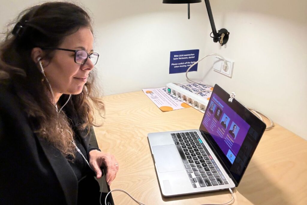 Melina mit Headset und Laptop bei der Arbeit