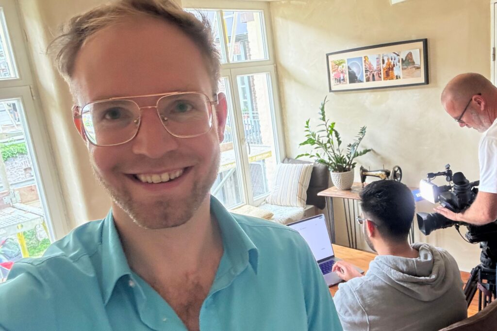 Oliver dokumentiert den Lokalzeit-Dreh mit Kunal im Hintergrund mit einem Selfie